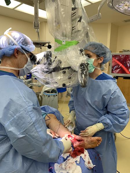 doctors in surgery using microscope